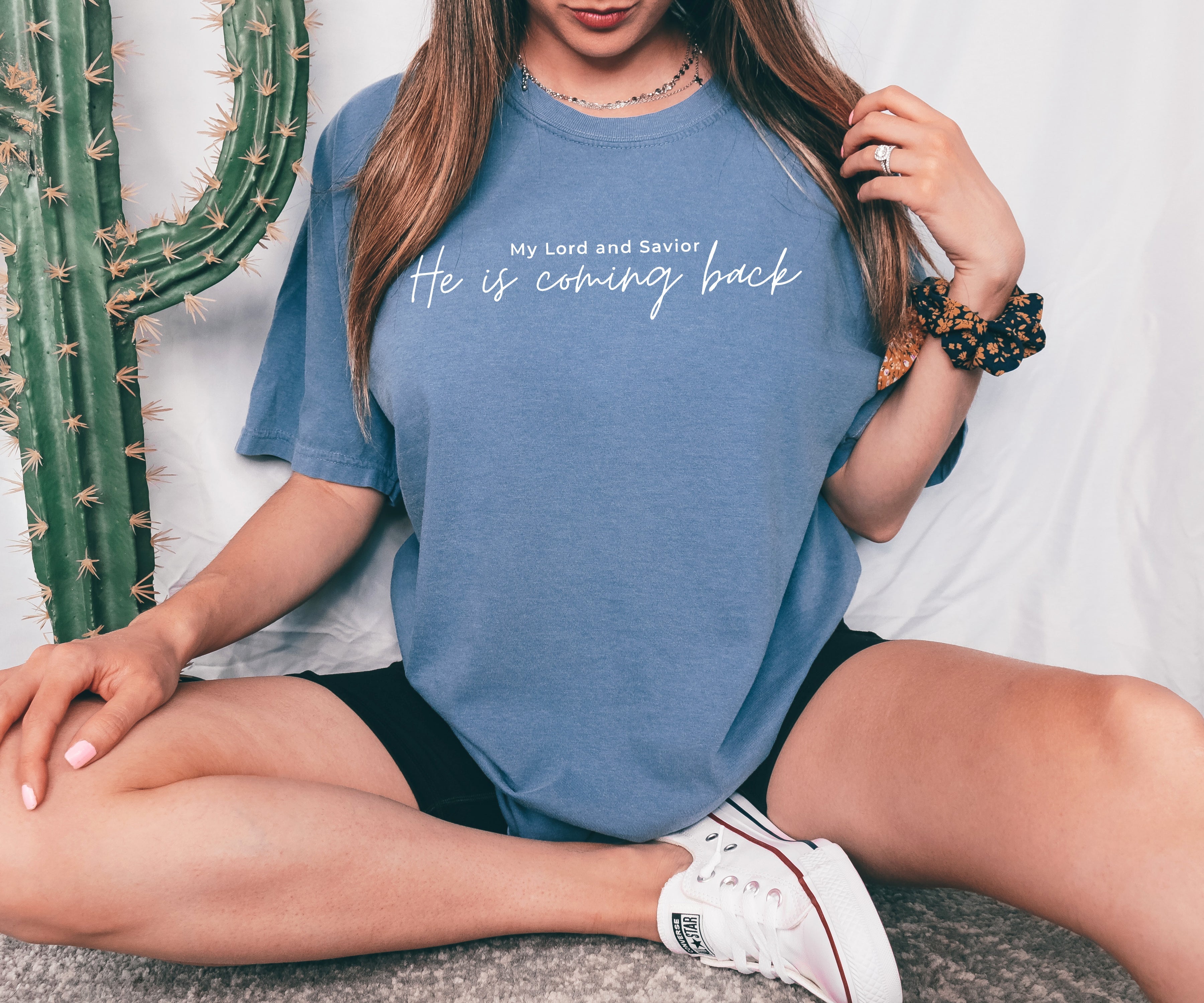 Blue T-shirt with white 'He is coming back' script on the front