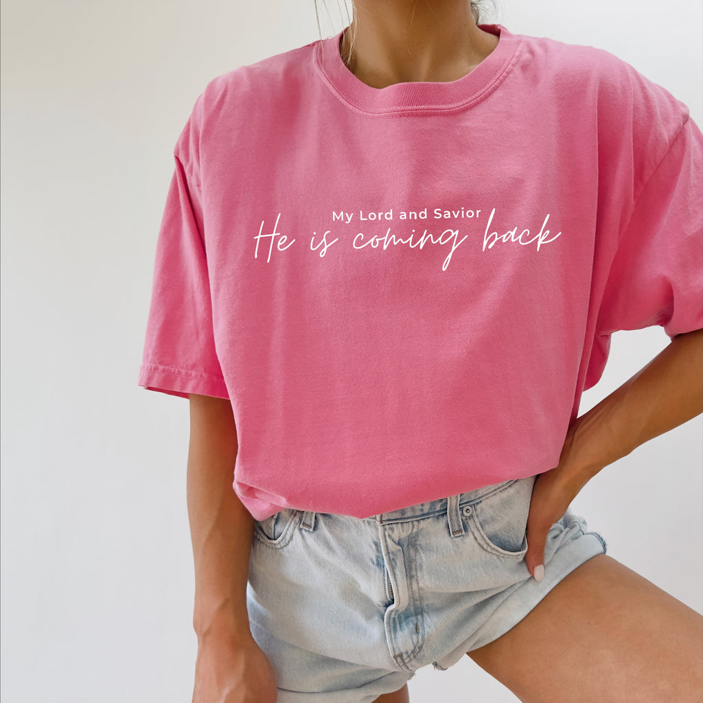 Pink T-shirt with white 'He is coming back' script on the front