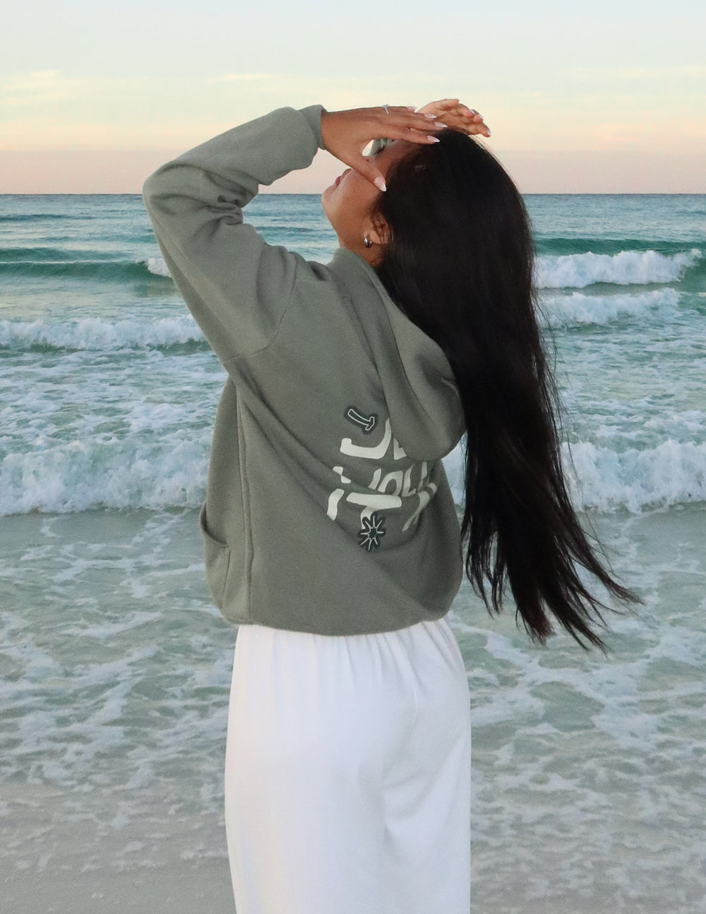 Unisex hoodie, dark green with front graphic text 'Jesus holds it all'
