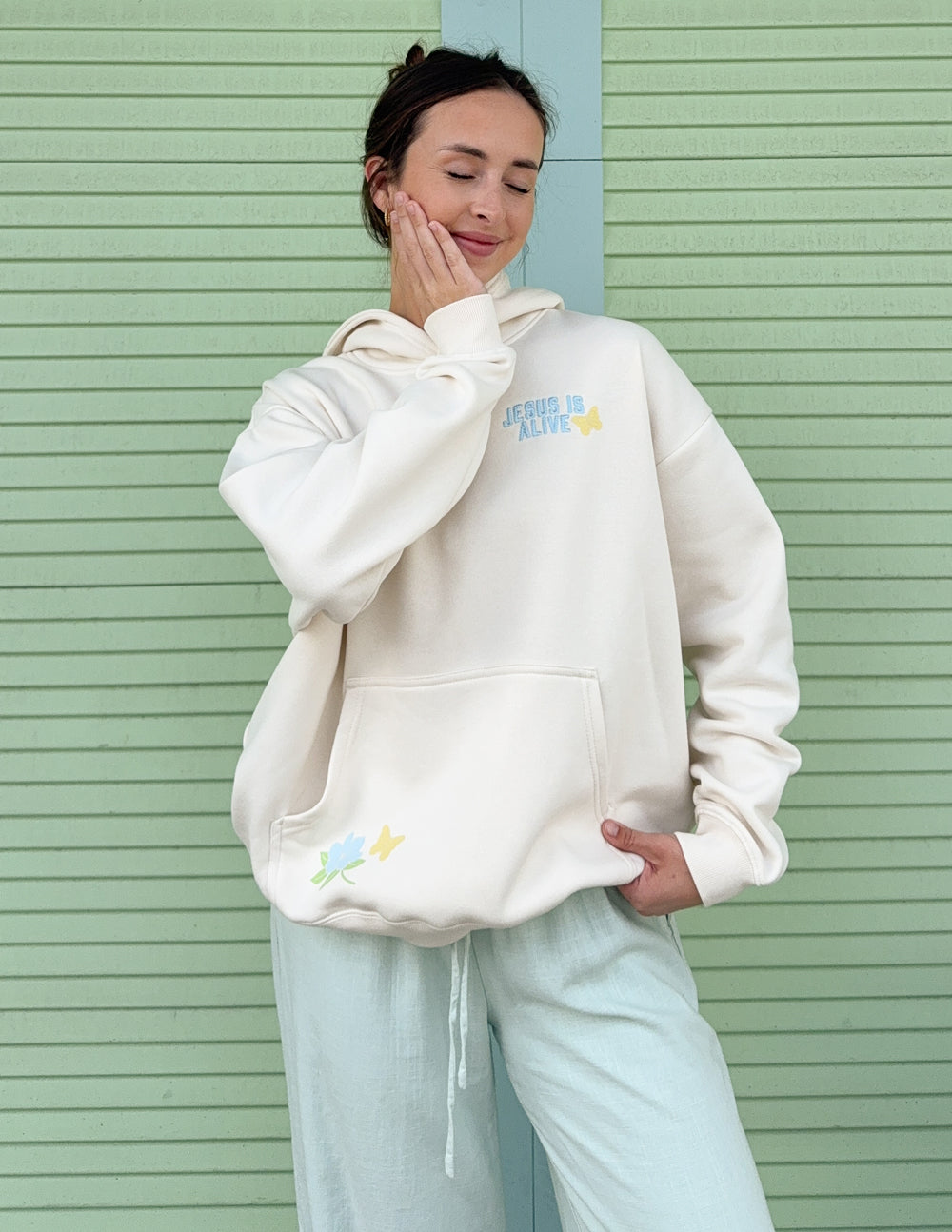 Unisex hoodie, cream, front pocket and chest graphic “JESUS IS ALIVE” with flowers