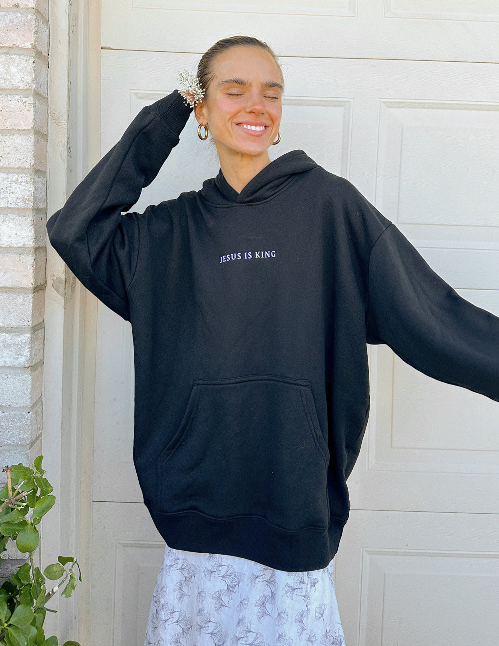 Black unisex pullover hoodie with small chest text and front kangaroo pocket