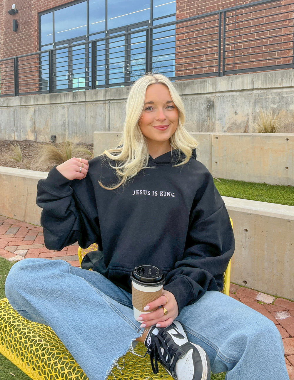 Black unisex pullover hoodie with small chest text and kangaroo pocket