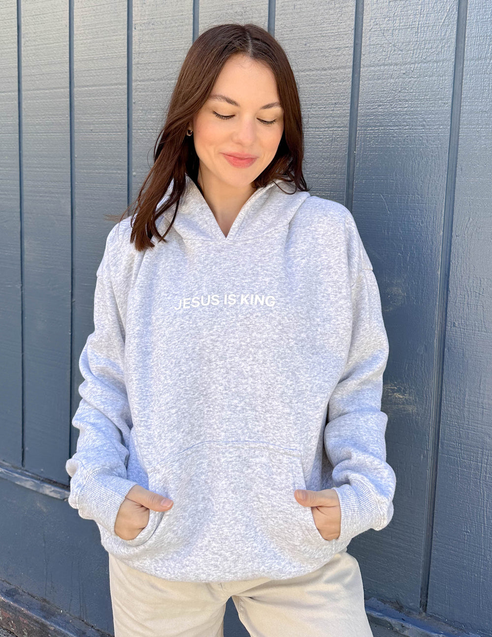 Heather grey unisex hoodie with hood, kangaroo pocket, and chest text