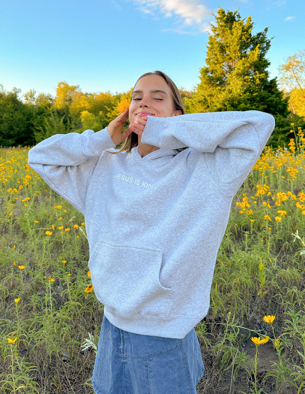 Heather grey unisex pullover hoodie with hood, long sleeves, and chest text