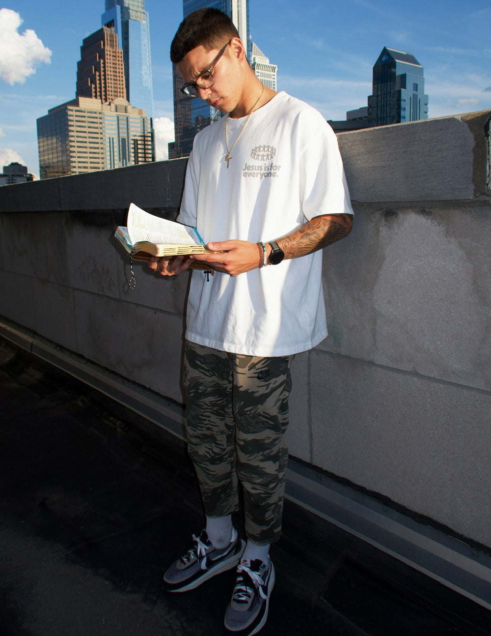 White heavyweight graphic T-shirt on man, worn with front chest logo visible