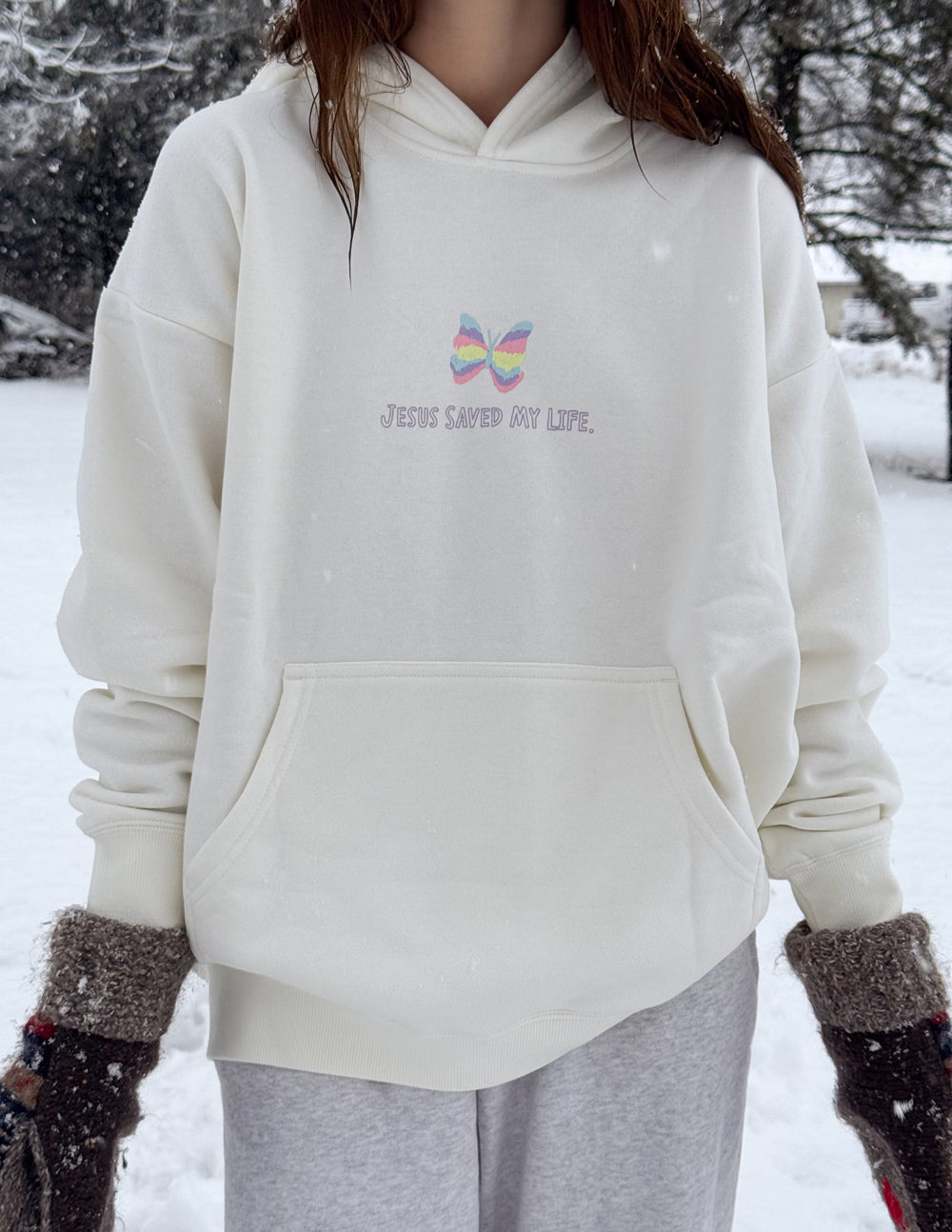 Unisex light-colored hoodie with small rainbow butterfly logo on chest