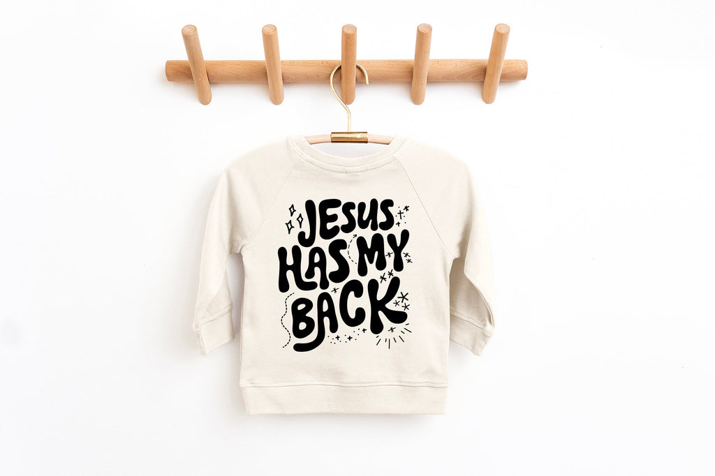 Toddler pullover sweatshirt in off-white with "Jesus has my back" graphic front