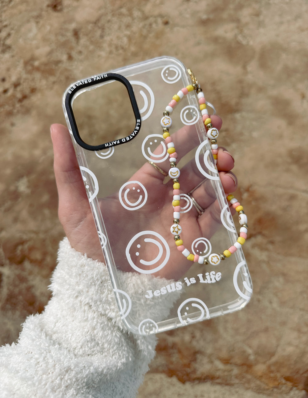 Beaded phone charm on clear phone case with smiley icons