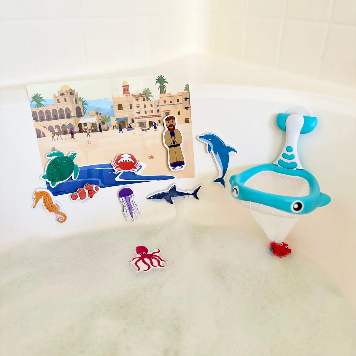 Blue dolphin bath net toy with mesh pouch and ocean animal sticker pieces in tub