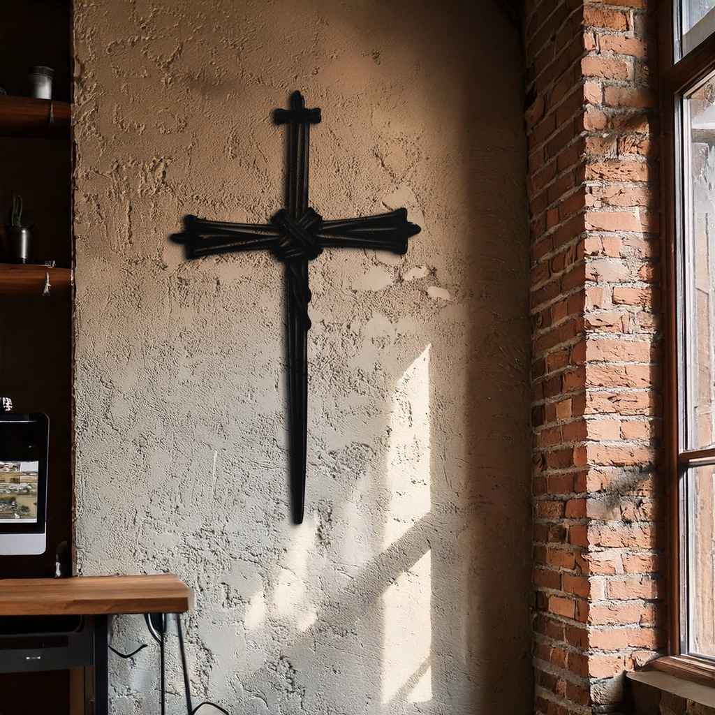 Black barbed wire cross metal wall art on textured wall