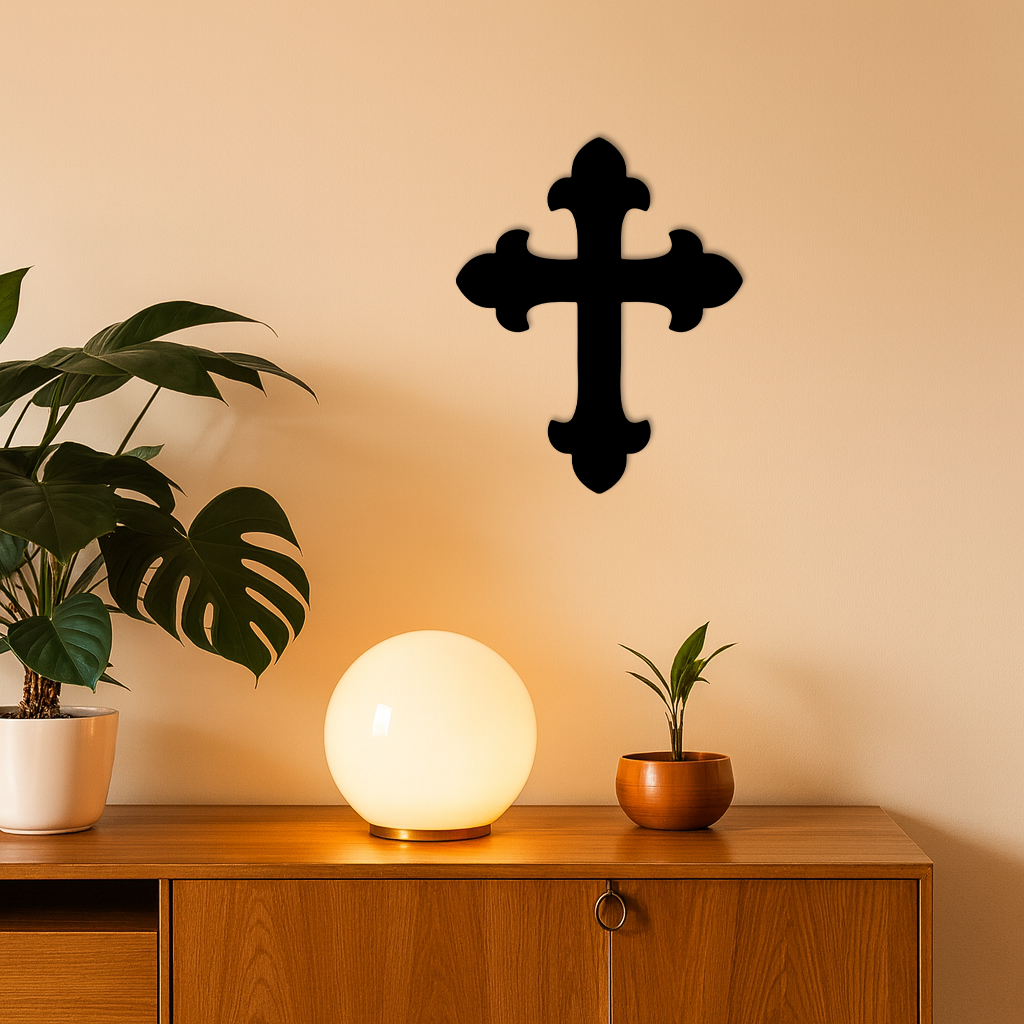 Black metal cross wall art on a warm light wall.