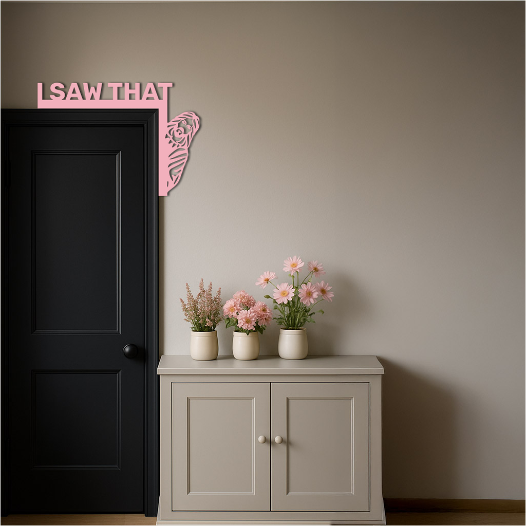 Pink corner metal wall art with 'I SAW THAT' text and rose swirl on wall by door