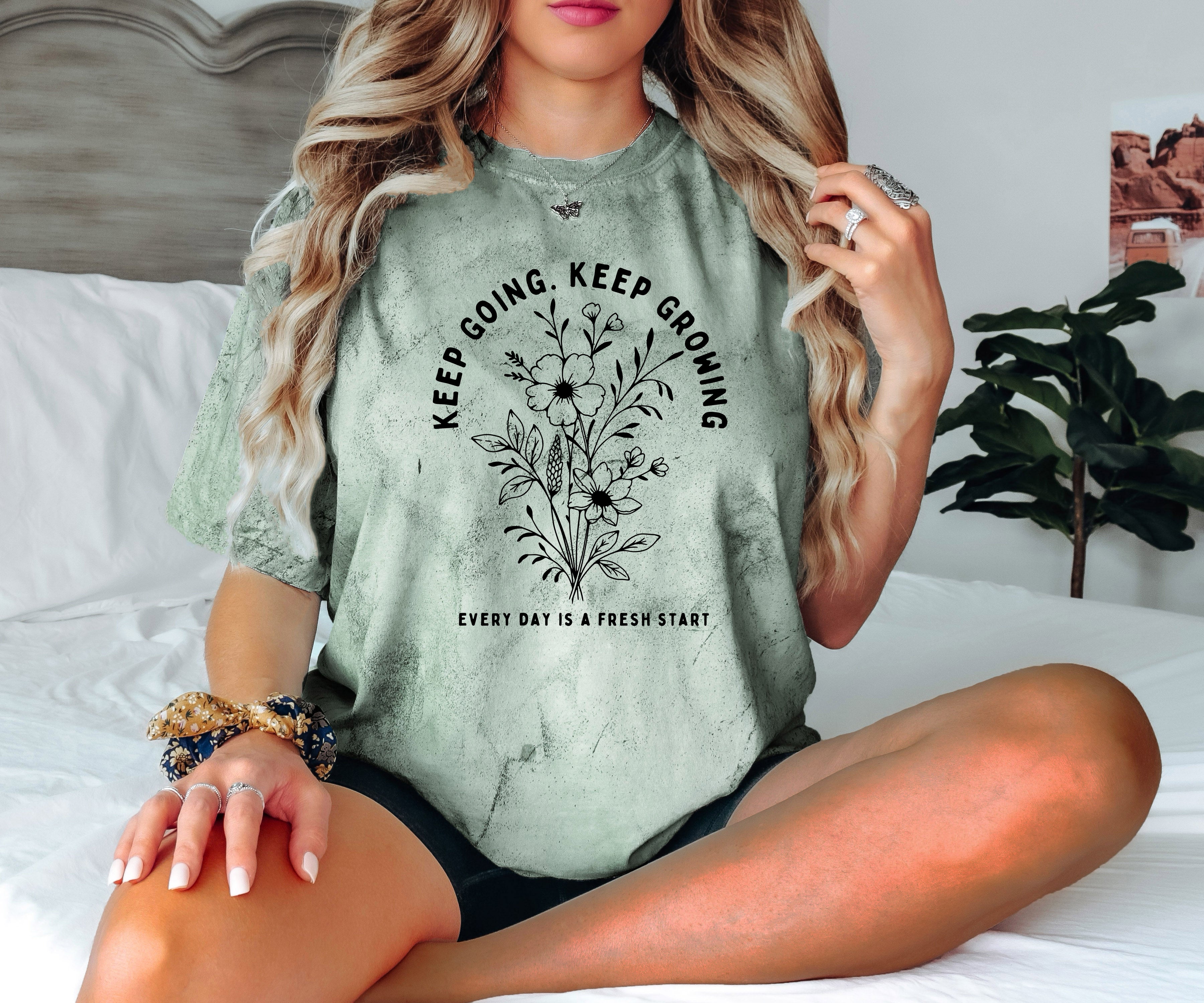 Green heather dyed graphic T shirt with floral wreath quote and crew neck