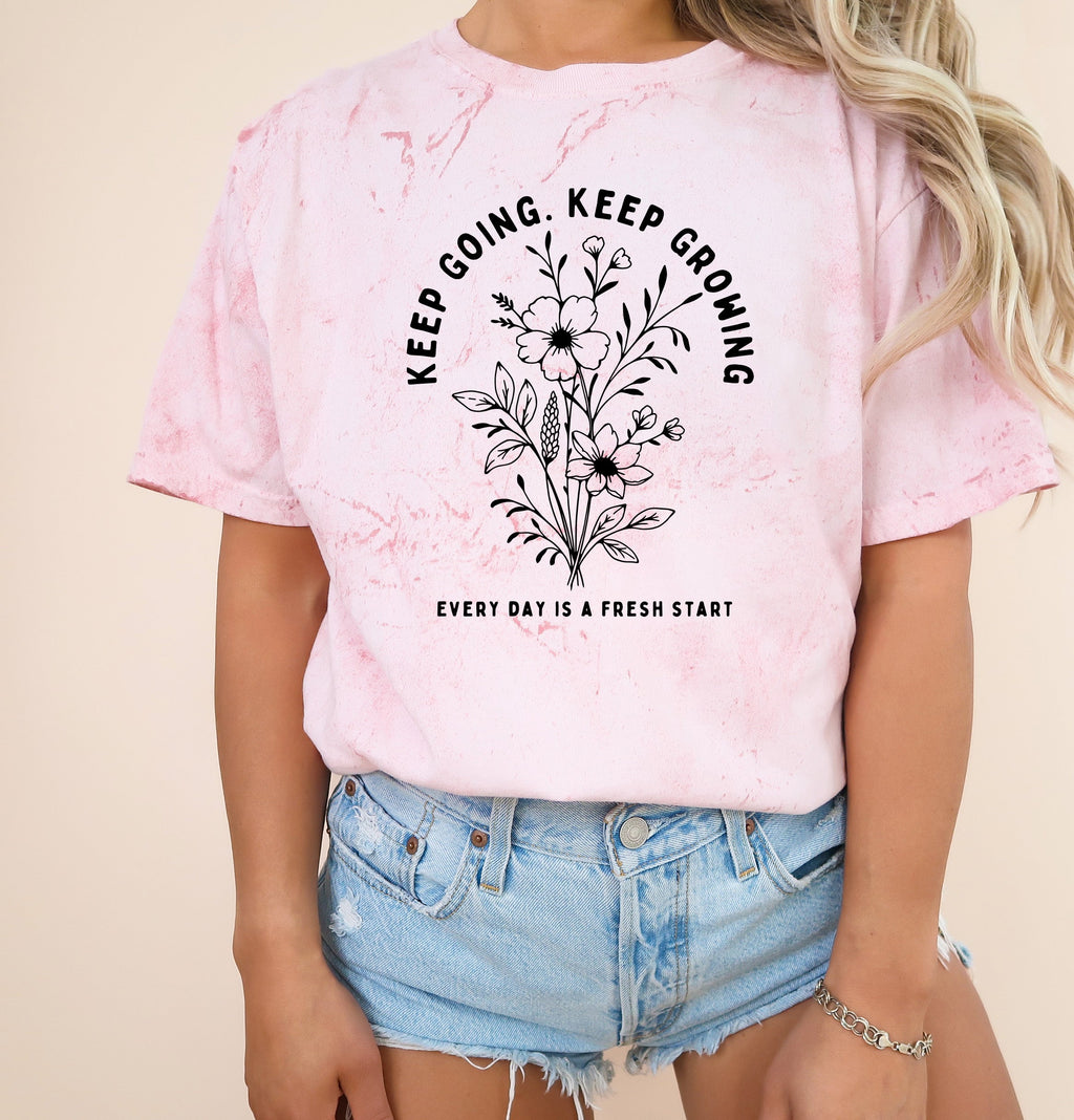 Light pink dyed graphic T shirt with floral wreath quote and crew neck