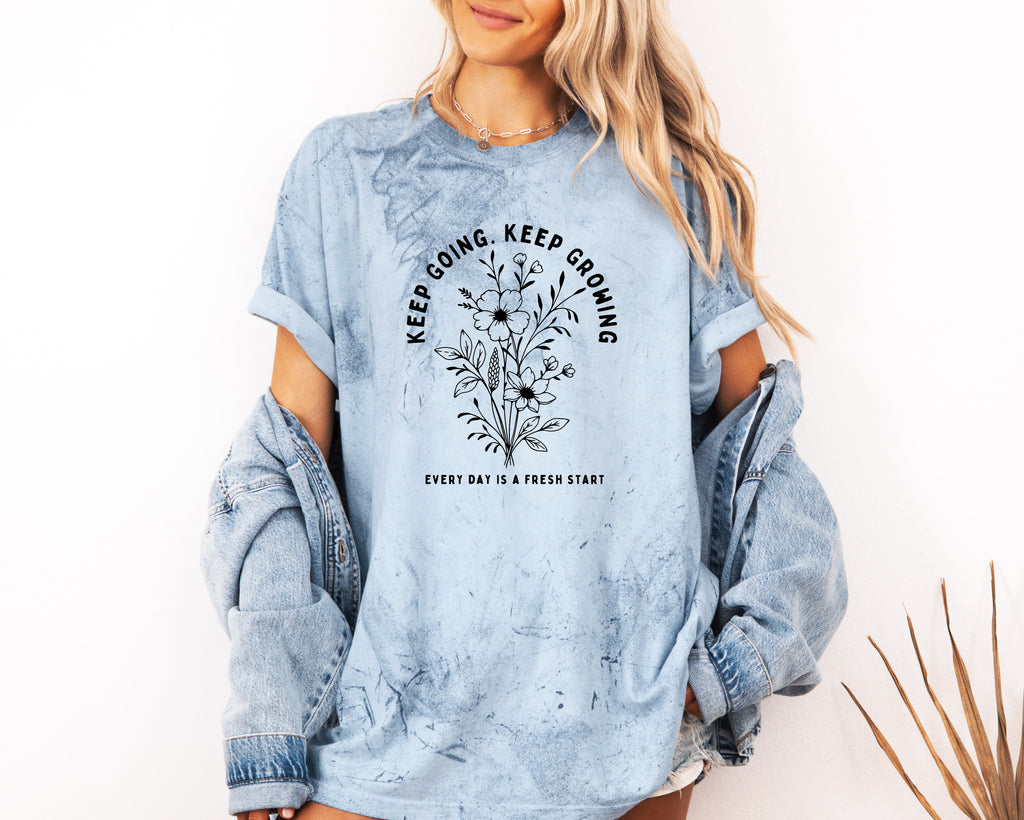 Light blue dyed graphic T shirt with floral wreath quote and crew neck