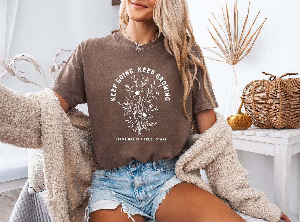 Espresso brown unisex T-shirt with white botanical quote graphic on front.
