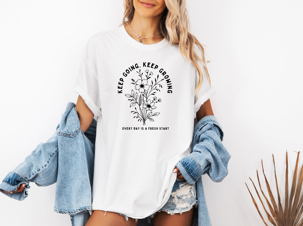 White unisex T-shirt with white botanical floral quote graphic on front.