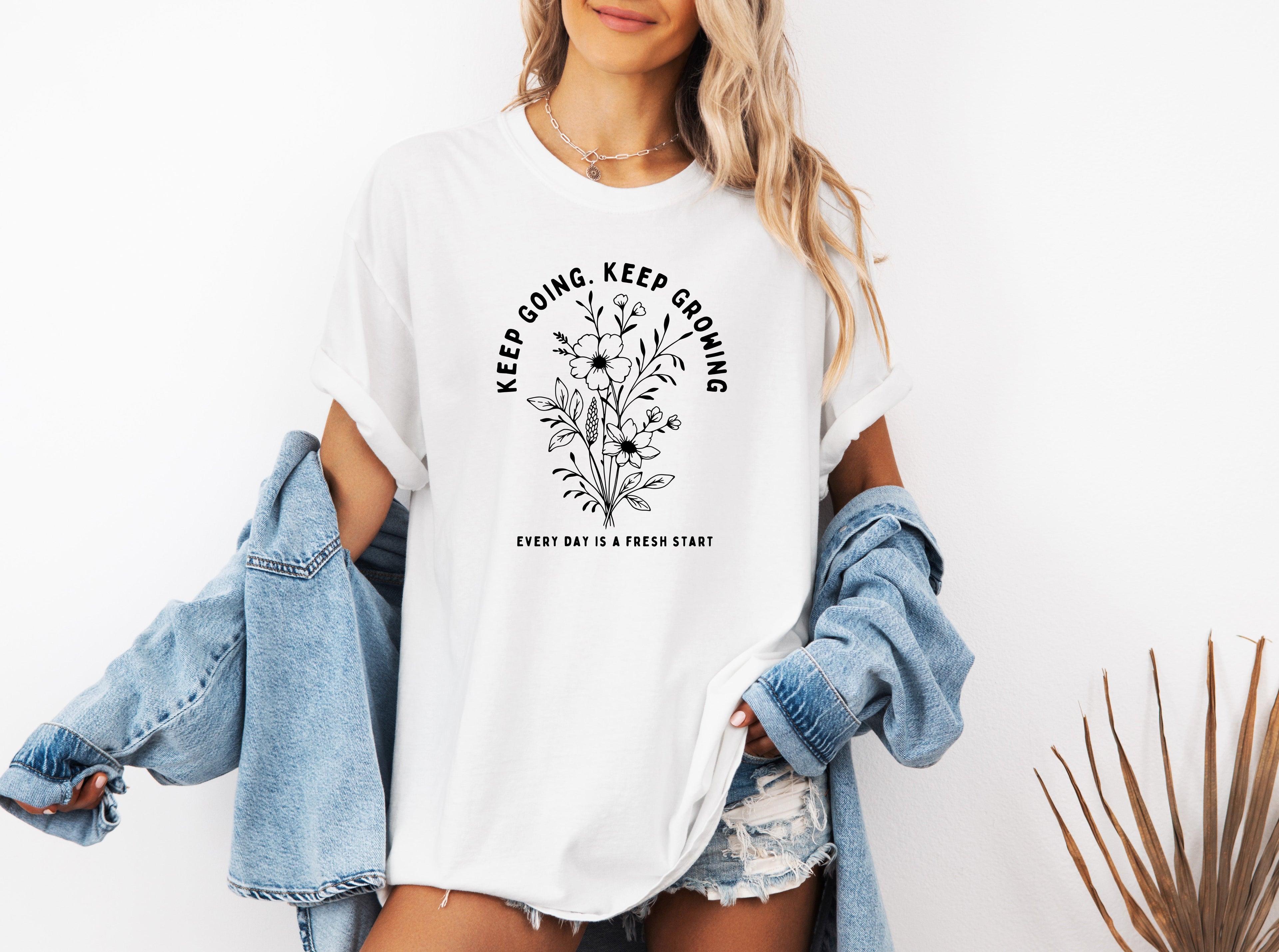 White unisex T-shirt with white botanical floral quote graphic on front.