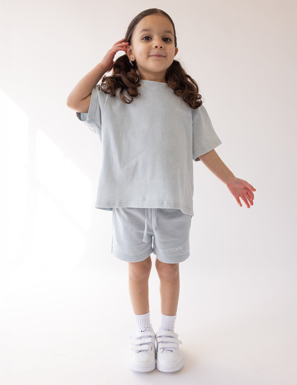 Kids light blue shorts with elastic drawstring waist and logo print, full outfit view