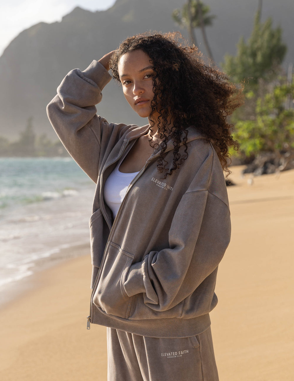 Brown full-zip hoodie with hood up, front zipper, and logo chest