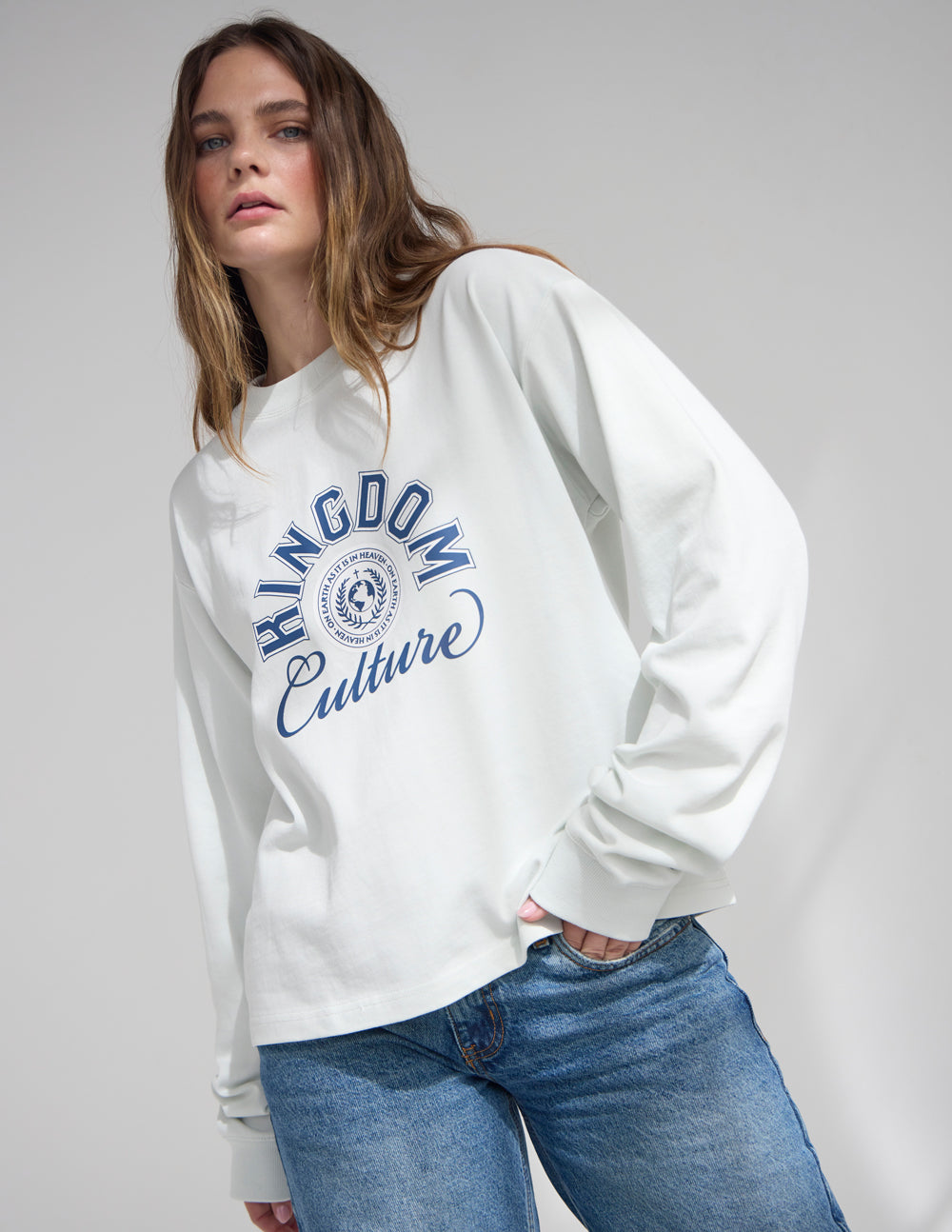 White long-sleeve crewneck tee with large Kingdom Culture logo, side view