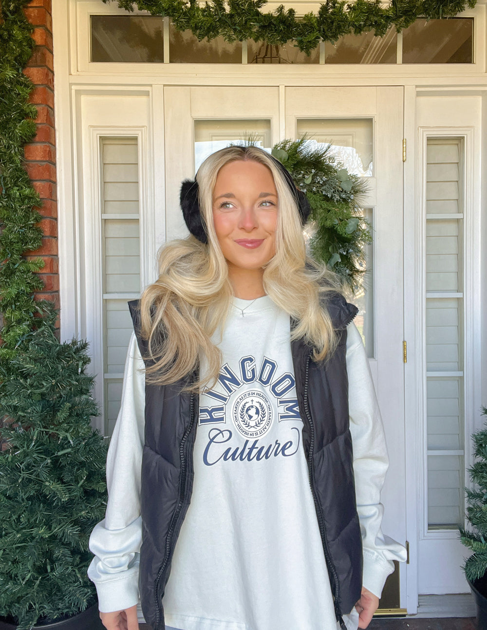 White long-sleeve tee with Kingdom Culture logo, worn under dark vest