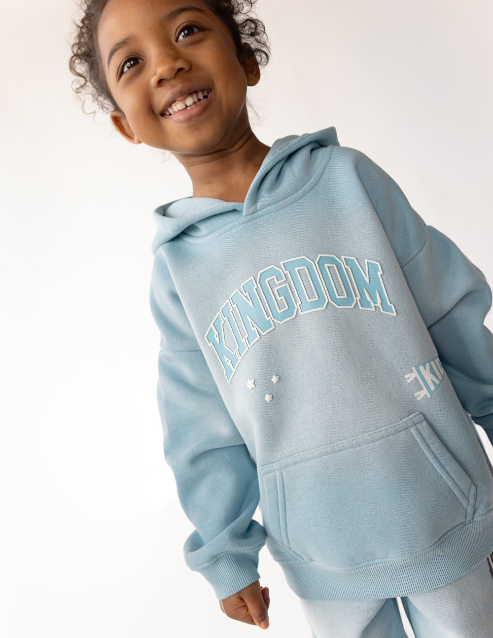 Kids light blue hoodie with Kingdom chest graphic and kangaroo pocket