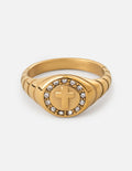 Gold signet ring with raised cross emblem and clear stone border