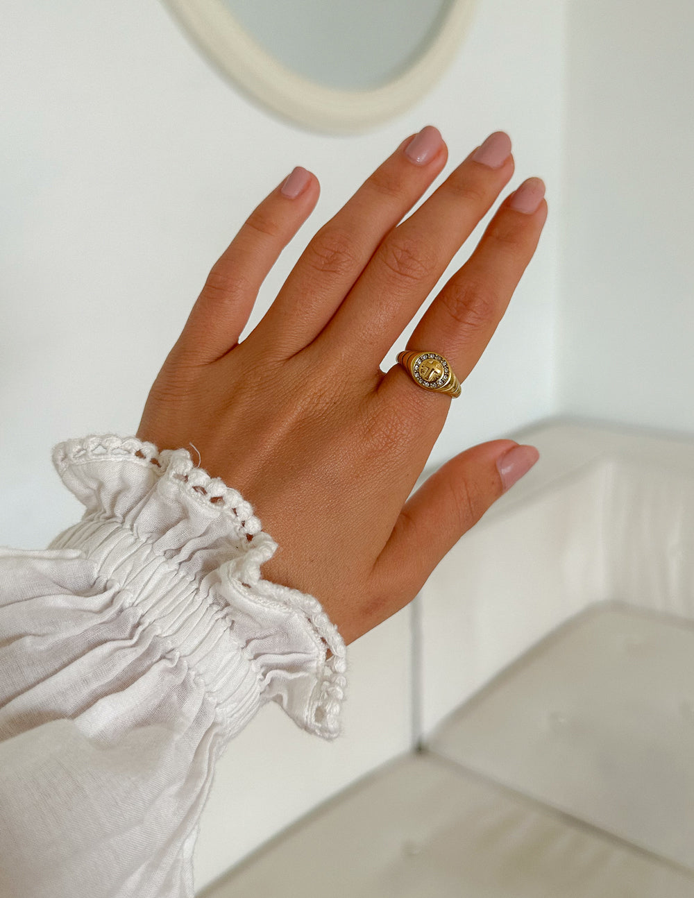 Gold cross signet ring with circular center and clear stones on the bezel