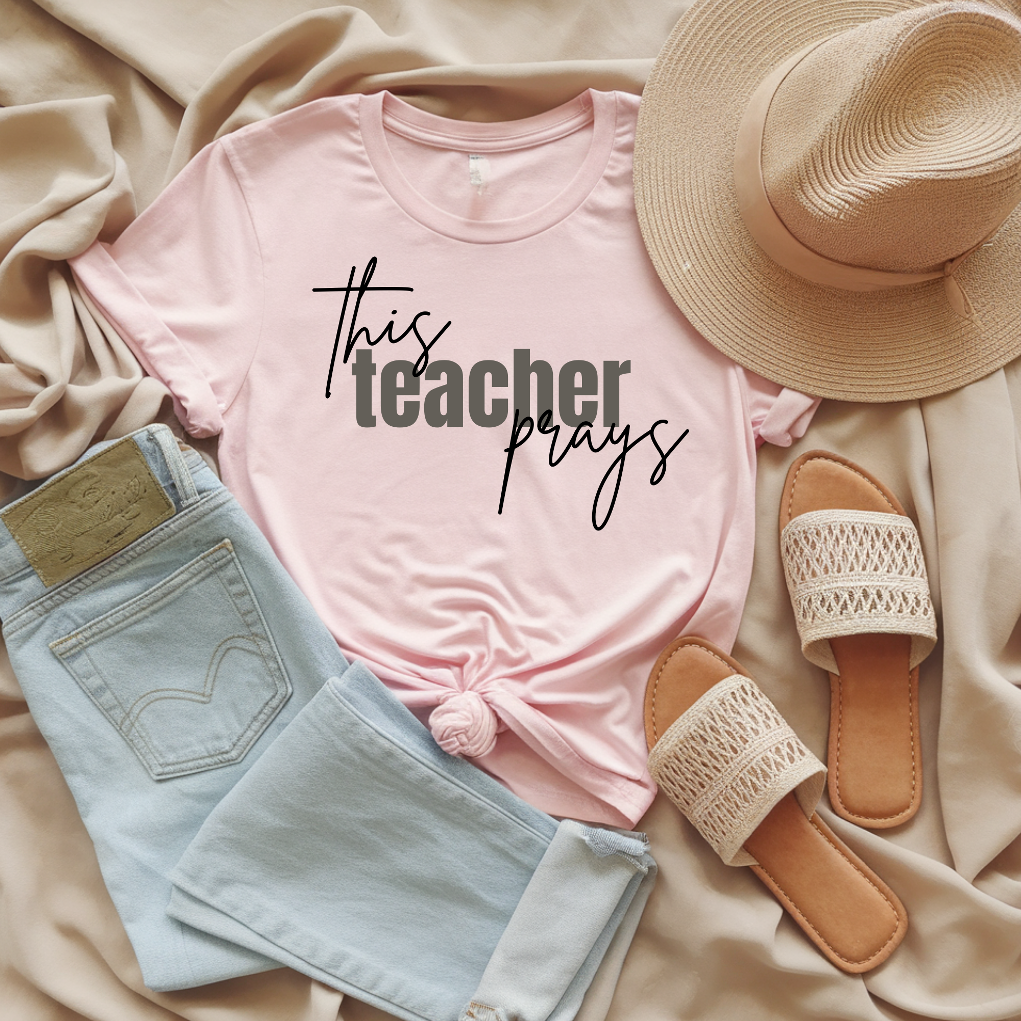 Pale pink T-shirt with 'This teacher prays' graphic print at center