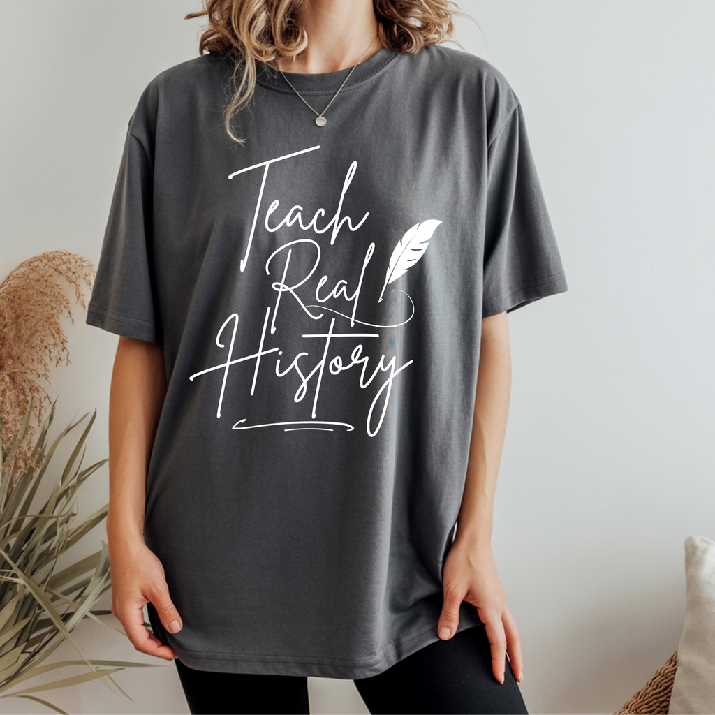 Graphic T-shirt in dark gray with 'Teach Real History' lettering and feather print