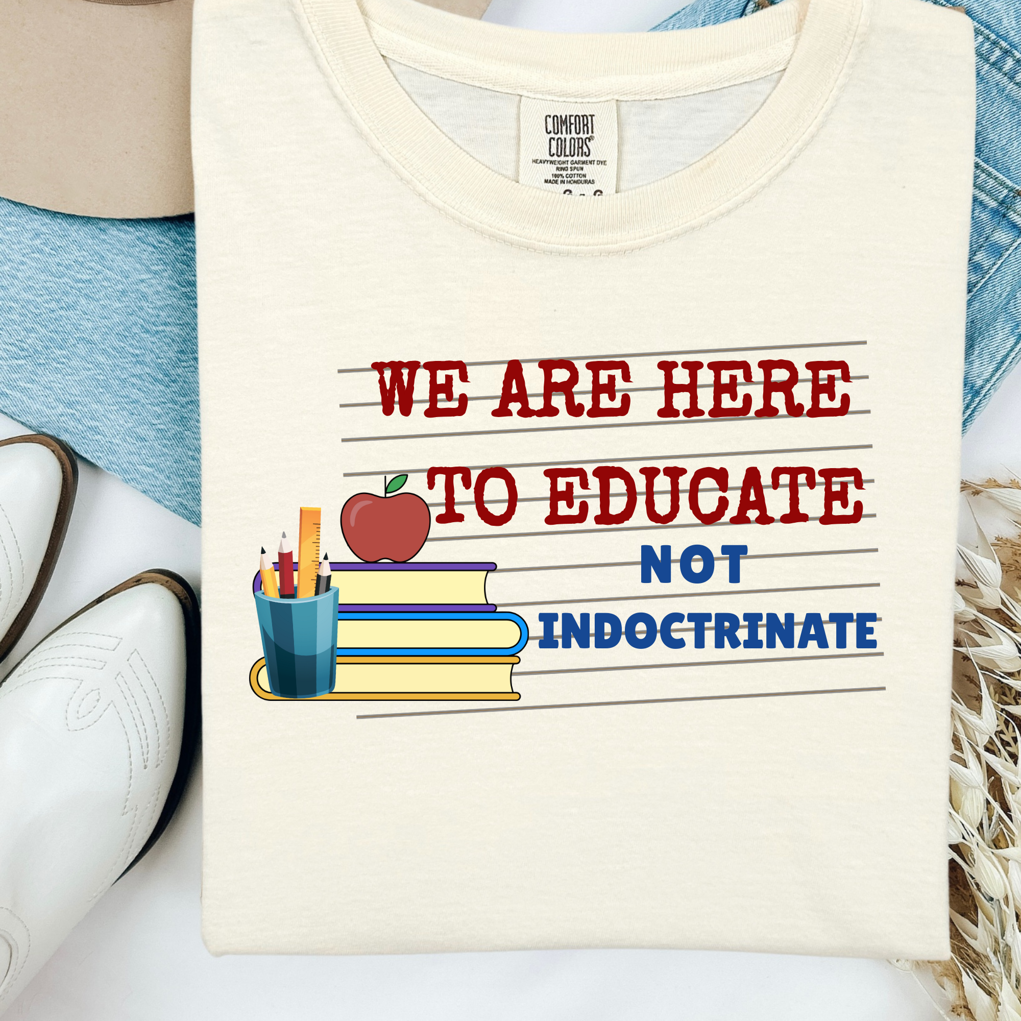 Cream T-shirt with 'We are here to educate' apple and book graphic