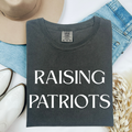 Charcoal Raising Patriots crewneck T-shirt with white text graphic, shown flat on denim