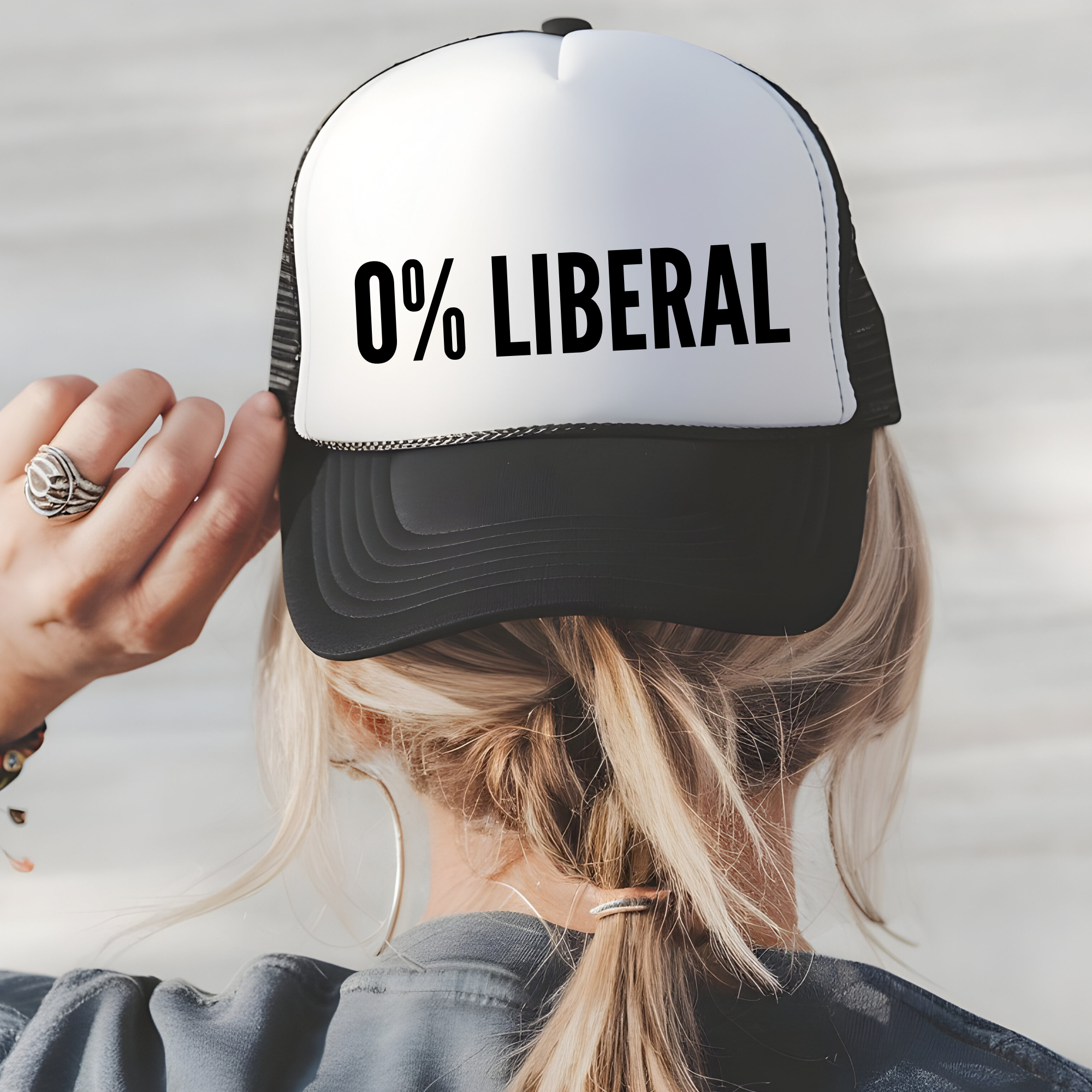 Trucker hat with white front panel and black brim, featuring '0% LIBERAL' text