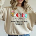 Cream crewneck sweatshirt with colorful teaching graphic and crew collar