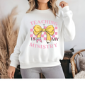 White crewneck sweatshirt with pink bow graphic and teaching ministry text