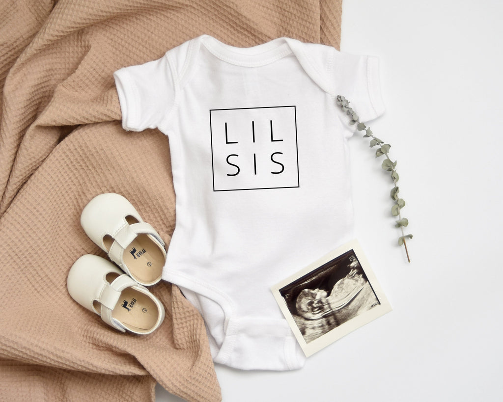 White baby bodysuit with LIL SIS logo print and snaps
