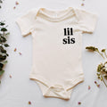 Cream baby onesie with 'lil sis' chest print, short sleeves and snap legs
