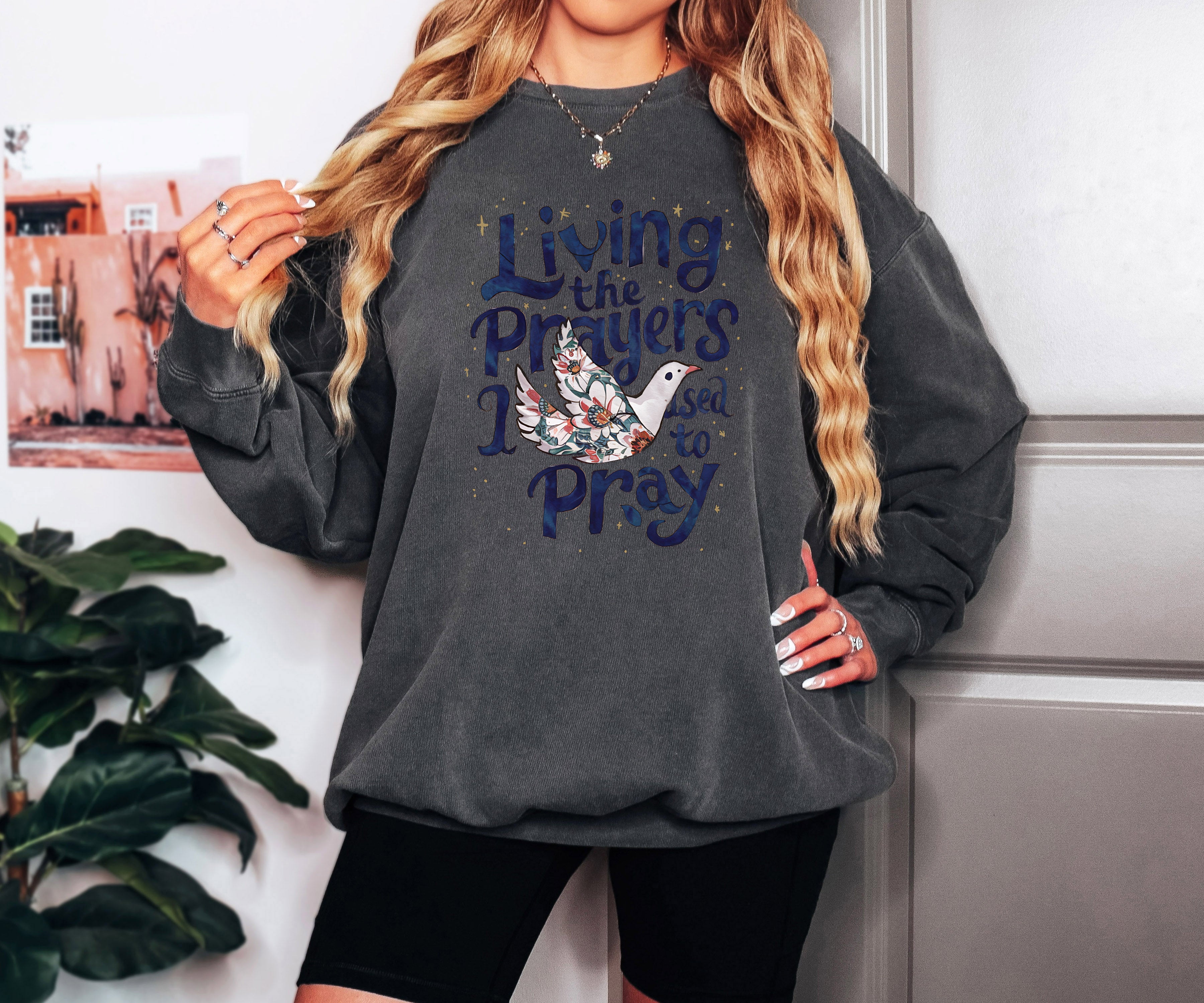 Charcoal crewneck sweatshirt with "Living the Prayers" floral cross graphic