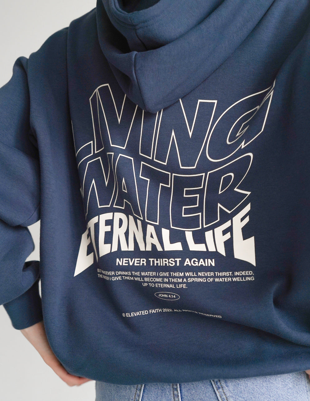 Dark blue hoodie with Living Water Eternal Life typography screen print detail.