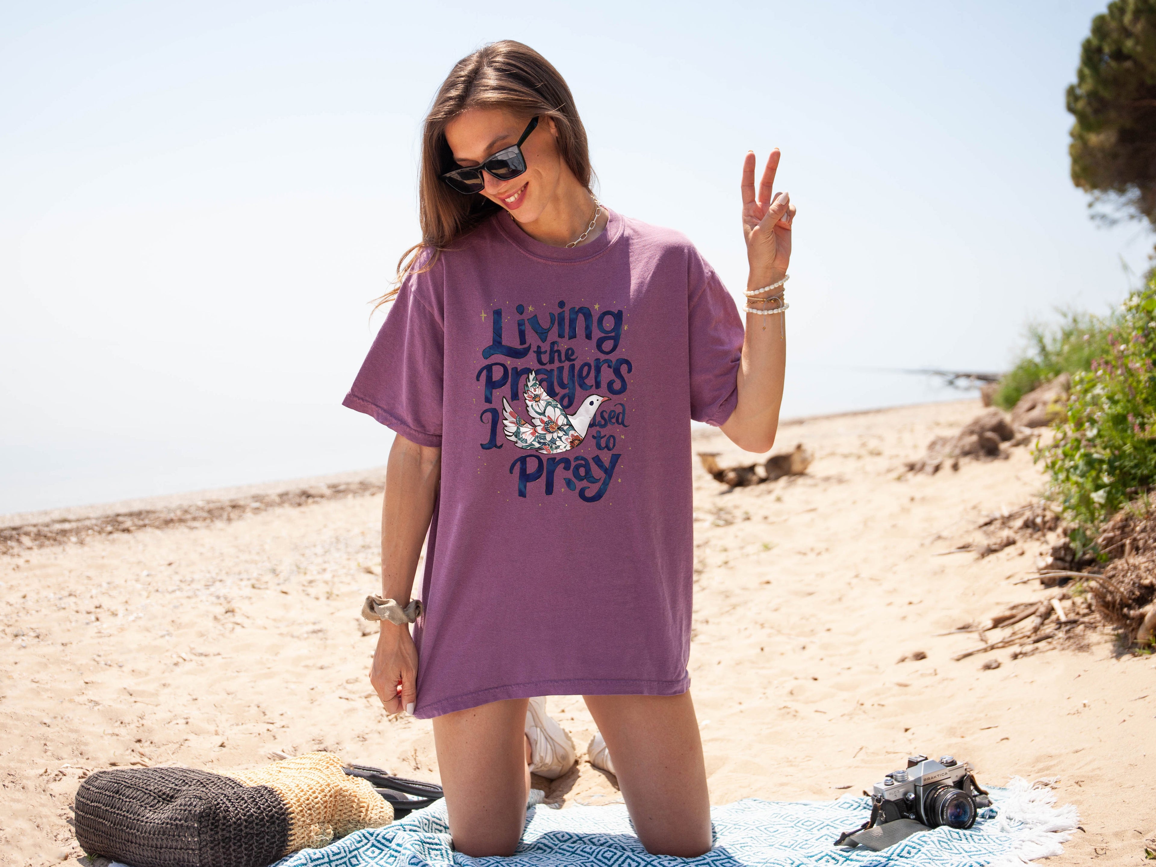 Purple unisex t-shirt with “Living the Prayers…Pray” front graphic