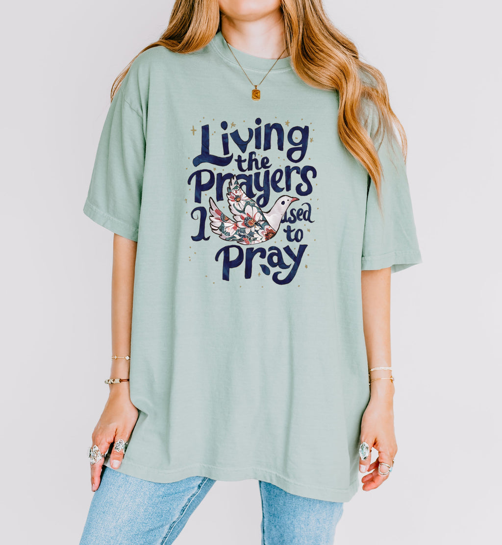 Light green unisex t-shirt with “Living the Prayers…Pray” front graphic