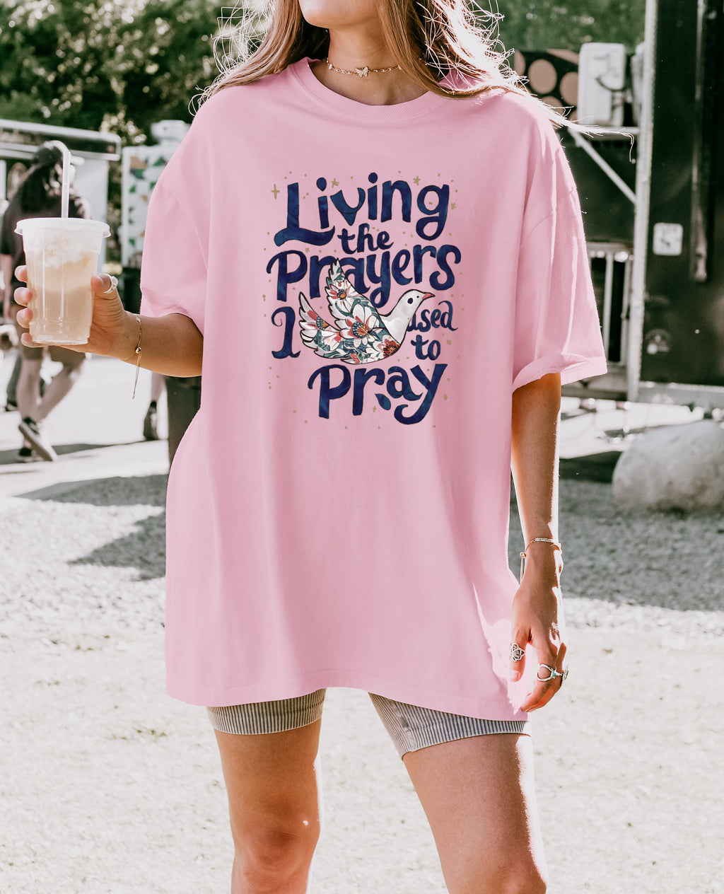 Orchid/pink unisex t-shirt with “Living the Prayers…Pray” graphic on front