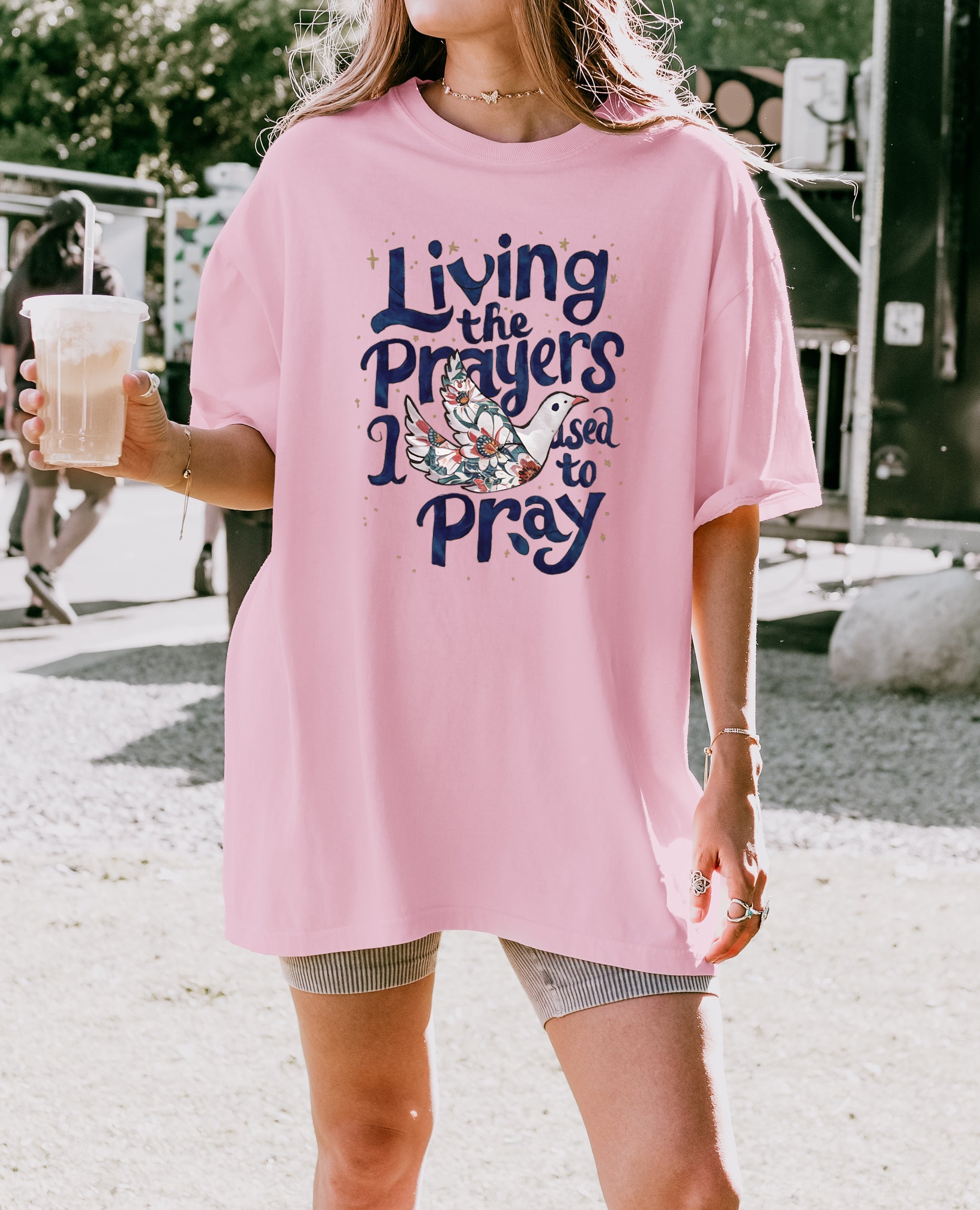 Orchid/pink unisex t-shirt with “Living the Prayers…Pray” graphic on front
