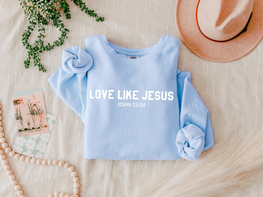 Light blue crewneck sweatshirt with “LOVE LIKE JESUS” and “John 13:34” print