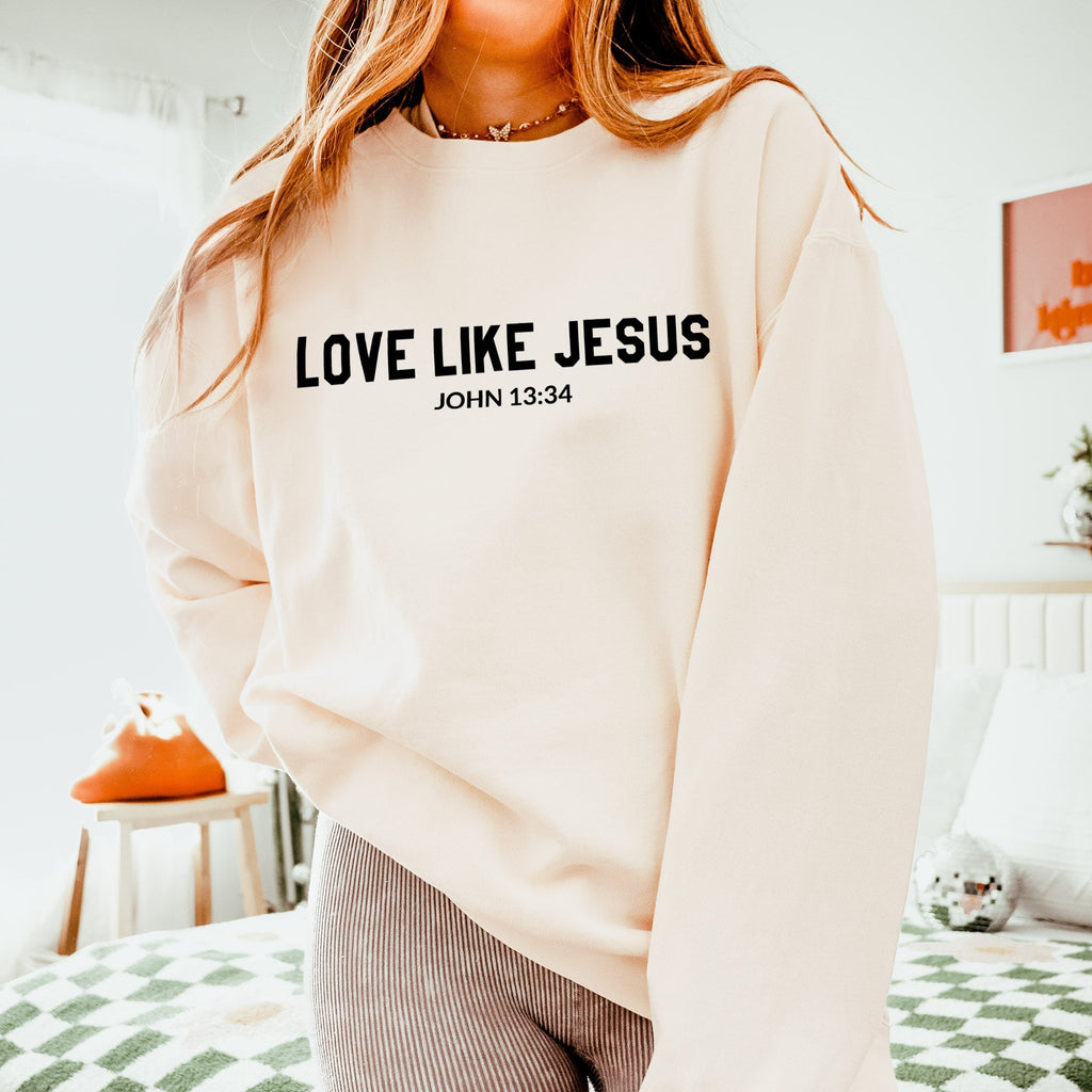 Cream crewneck sweatshirt with “LOVE LIKE JESUS” and “John 13:34” print