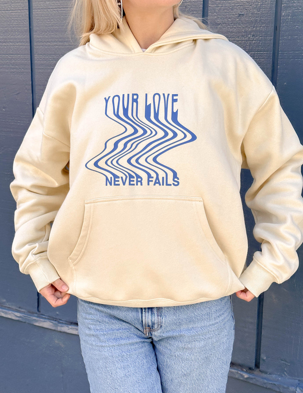 Cream unisex hoodie with blue 'Your Love' graphic, front pocket, and drawstring hood