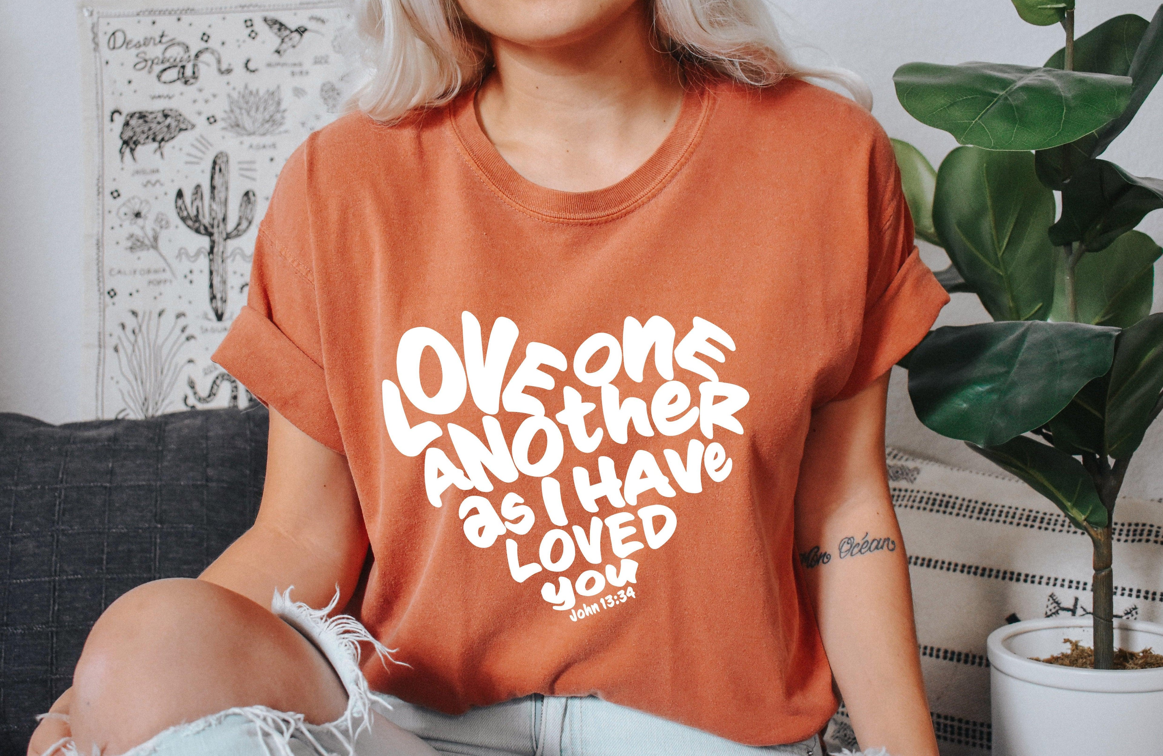 Unisex orange crewneck T-shirt with white inspirational text graphic