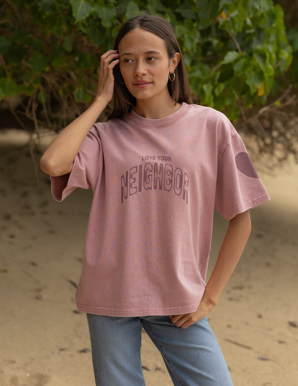 Pink heavyweight T-shirt with crew neck and 'Neighbor' front graphic logo, side view