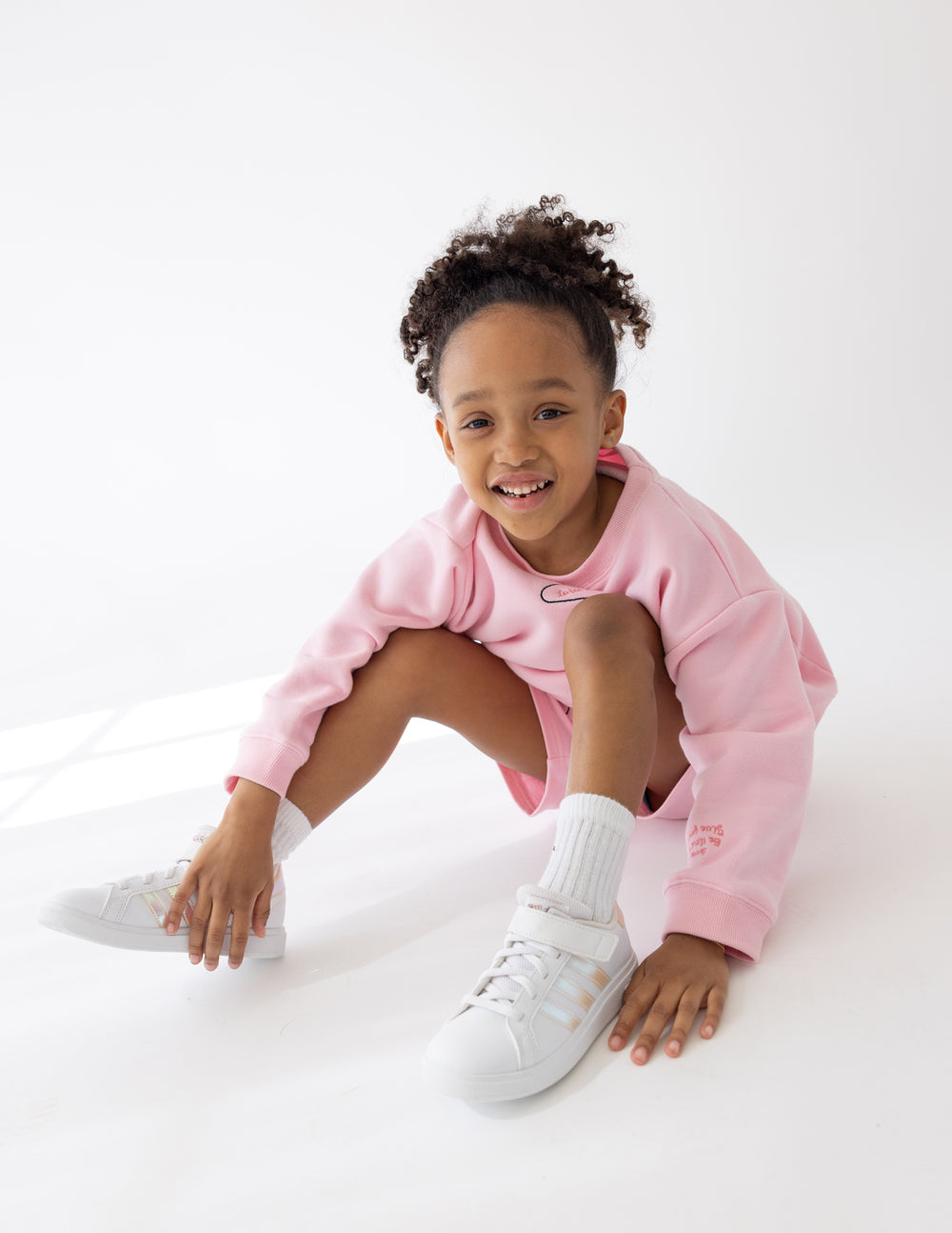 Kids pink crewneck sweatshirt with small heart outline graphic; long sleeves